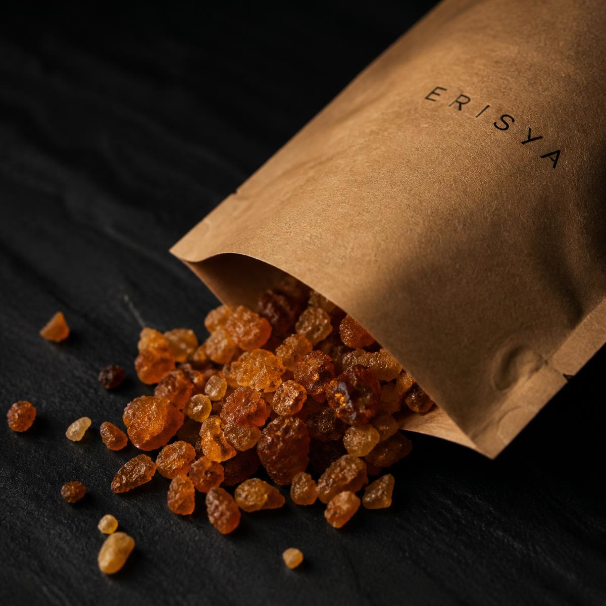 Granules ambrés de Boswellia serrata de l'Inde, en petit tas sur une pierre noire.